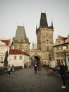 Pedestrians on Charles Bridge. Medieval gothic tower with a gate