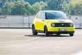 Prague, Czech republic - October 02, 2020. Two men driving in yellow green electric Honda E - side view