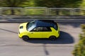 Prague, Czech republic - October 02, 2020. Yellow green electric Honda E in move on tar road - bird perspective