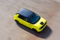 Prague, Czech republic - October 02, 2020. Yellow green electric Honda E in move - view to the rooftop