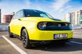 Prague, Czech republic - October 02, 2020. Yellow green electric Honda E - parked on asphalt parking - side view
