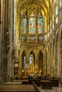 PRAGUE, CZECH REPUBLIC - OKTOBER 10, 2018: Tourists inside Vitus Cathedral near the altar with mosaic on glass window