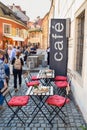 PRAGUE, CZECH REPUBLIC - OKTOBER 11, 2018: Tourists near red chairs and tables in a street cafe in the Czech Republic Royalty Free Stock Photo