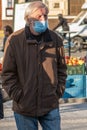 11/16/2020. Prague, Czech Republic. An old man is wearing masks while crossing the street close to Hradcanska tram stop during