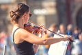 A young violinist girl performs in the street