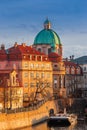 Prague, Czech Republic - The world famous St. Francis of Assisi Church dome and traditional red rooftops with beautiful golden sun