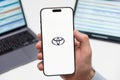 Tayota automobile logo on the screen of smartphone in mans hand