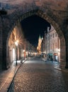 Prague, Czechia - 02.17.2022: View through Mala Strana Tower Bridge arch in the dark night on the Charles Bridge. Center Royalty Free Stock Photo