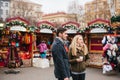 Prague, December 15, 2016: European couple man and woman in the Christmas market drink hot mulled wine and watch