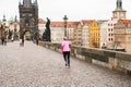 Prague, December 24, 2016: The girl athlete has a morning run in the winter on the Charles Bridge in Prague in the Czech