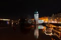 Prague at night, boat on the dock of the Vltava river, reflection of lights