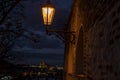 Light into the street lights on an old stone wall at night and in the background a prague castle Royalty Free Stock Photo