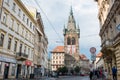 Prague street with people and traffic and Henry tower on the background