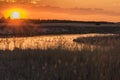Orange Sky With Setting Sun Over Prairie Grass and River Royalty Free Stock Photo