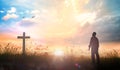 Human standing and the cross on meadow sunset Royalty Free Stock Photo