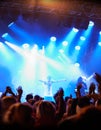 Praising the party people. Rearview of an audience with hands raised at a music festival and lights streaming down from Royalty Free Stock Photo