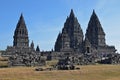 Prambanan Temples with stone ruins and tourists carrying umbrella leaving & entering the complex