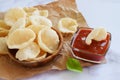 Prawn Crackers or Shrimp Chips with ketchup served on parchment paper, Fresh Krupuk on bright background