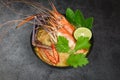 Prawn spicy soup bowl with spices ingredients on dark background - Cooked seafood with shrimp soup dinner table thai food asian Royalty Free Stock Photo