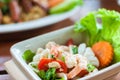 Prawn and squid spicy salad on dish wood background, Thai traditional mix seafood Royalty Free Stock Photo