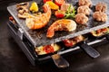Prawn tails and meatballs cooking with raclette Royalty Free Stock Photo