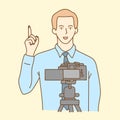 Camera recording a young male blogger talking while making a video