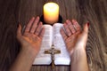 Pray. Female hands near the bible and candles on a wooden table Royalty Free Stock Photo