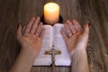 Pray. Female hands near the bible and candles on a wooden table Royalty Free Stock Photo