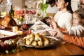Happy family celebrate Thanksgiving day, sitting at table with roasted turkey and holiday traditional food, dishes. Royalty Free Stock Photo