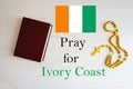 Pray for Ivory Coast. Rosary and Holy Bible background Royalty Free Stock Photo