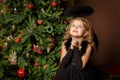 Pray a little girl in a black angel costume, looking with hope for peace. Happy childhood and peace. Christmas, New Year Royalty Free Stock Photo