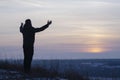 Pray. Repentance. Silhouetted men on a background of blue sky and sunset. Kneeling Prayer to God. Glorification. Praising God. A m