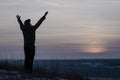 Pray. Repentance. Silhouetted men on a background of blue sky and sunset. Kneeling Prayer to God. Glorification. Praising God. A m Royalty Free Stock Photo