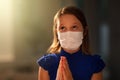 Pray for the sick. Child in face mask praying Royalty Free Stock Photo