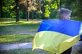 Pray for Ukraine. boy with Ukrainian flag running the summer park. Little kid waving national flag praying for peace. Happy child Royalty Free Stock Photo