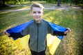 Pray for Ukraine. boy with Ukrainian flag running the summer park. Little kid waving national flag praying for peace. Happy child Royalty Free Stock Photo