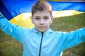 Pray for Ukraine. boy with Ukrainian flag running the summer park. Little kid waving national flag praying for peace. Happy child Royalty Free Stock Photo