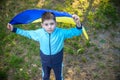 Pray for Ukraine. boy with Ukrainian flag running the summer park. Little kid waving national flag praying for peace. Happy child Royalty Free Stock Photo