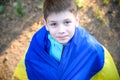 Pray for Ukraine. boy with Ukrainian flag running the summer park. Little kid waving national flag praying for peace. Happy child Royalty Free Stock Photo