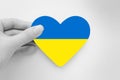 Humanitarian aid concept. Pray for Ukraine. Female hands hold a heart with the flag of ukraine. Ukraine`s Independence Day