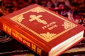 Prayer Book with Orthodox Cross on table with soft flickering candlelight