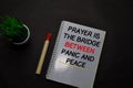 Prayer is the Bridge Between Panic and Peace write on a book on office desk. Christian faith concept