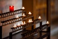 Prayer candles lit inside a church as a votive offering in an act or prayer Royalty Free Stock Photo