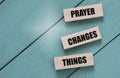 PRAYER CHANGES THINGS - words on wooden blocks on a turquoise background Royalty Free Stock Photo