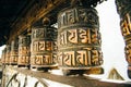 Prayer drum. Old prayer cylinders in Nepal. Tibetan Prayer wheels. Buddhist rolls in row Royalty Free Stock Photo