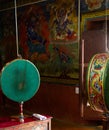 Prayer drum and wall paintings in the buddhist temple