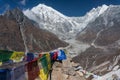 Prayer flags and View to Langtang Lirung summit from Kyngin Ri. Royalty Free Stock Photo