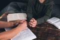 Prayer. A group of Christians pray holding hands. On the table. The Holy Bible is open. Praying