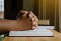 Prayer hands on a Holy Bible on wood table with window light.christian backgound. Royalty Free Stock Photo