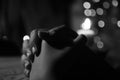 Prayer hands of a young girl with candle light on the table in black and white background. Keep praying concept. Faith love hope Royalty Free Stock Photo